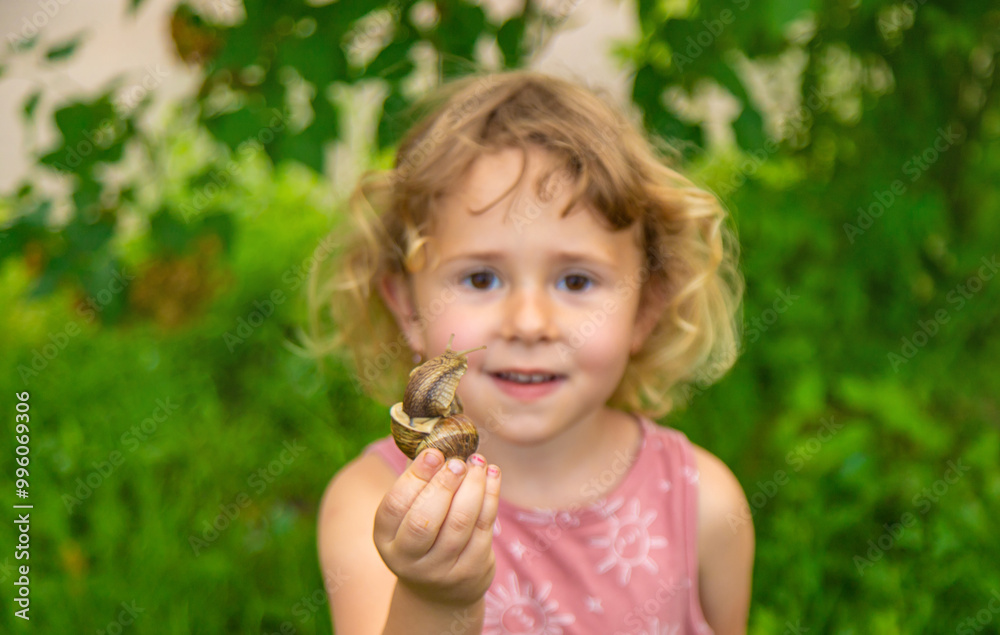 Child holding a snail on his hand. Selective focus. Child holding a snail on his hand. Selective focus.