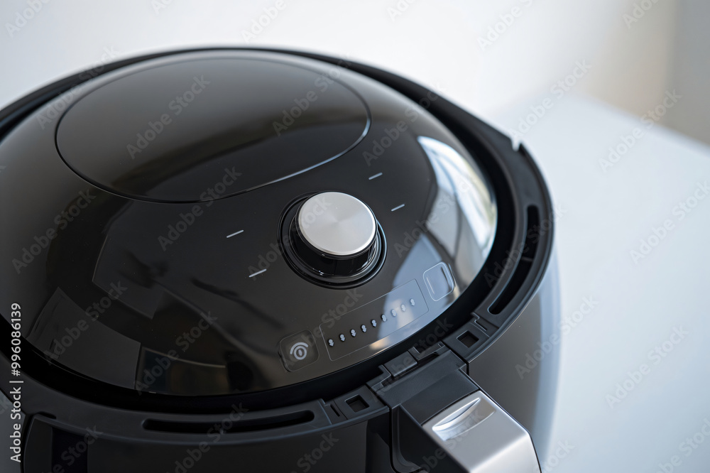 Sleek, modern black air fryer with a clean design and a control panel displaying various cooking settings Sleek, modern black air fryer with a clean design and a control panel displaying various cooking settings