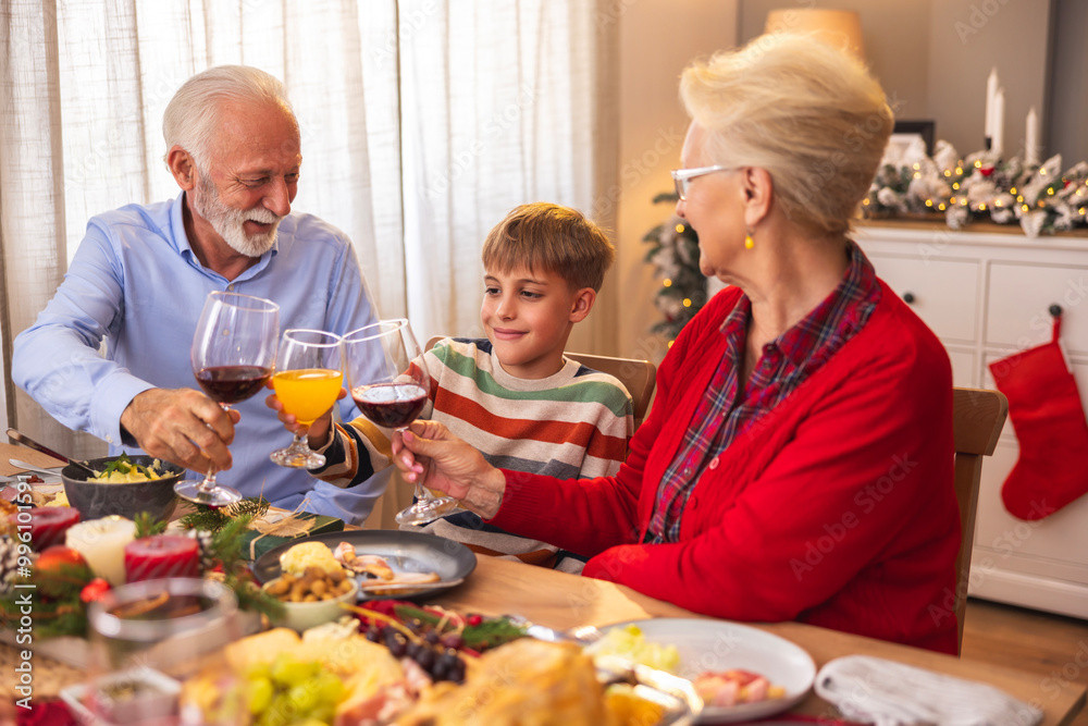 Boy making a toast with grandparents while having family Christmas dinner Boy making a toast with grandparents while having family Christmas dinner