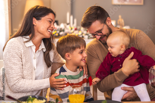 Beautiful young family having Christmas dinner at home photo