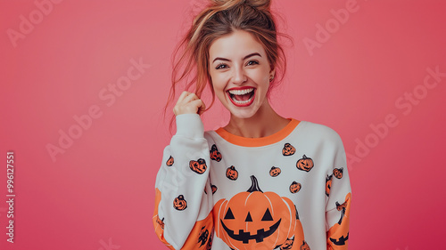 Close-up of a cute, attractive and cheerful woman with red lips smiling poses flirtatiously wearing a beautiful white happy halloween sweatshirt, pink background, space for text, spooky session. photo