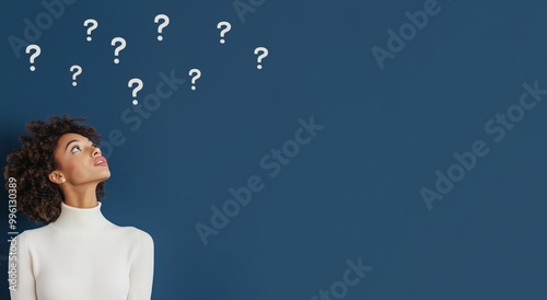 Black Afro American young woman in indecision, surrounded by question mark, on dark blue background with space to copy. Brainstorming and decision making, searching for answers.