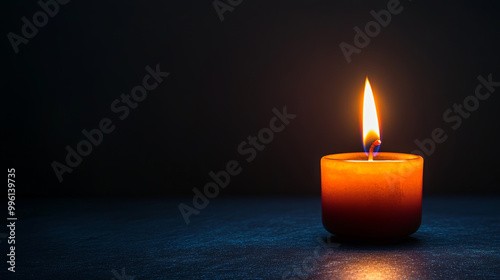 single candle flame flickers softly in darkness, casting warm glow against dark grey background, creating serene and peaceful atmosphere