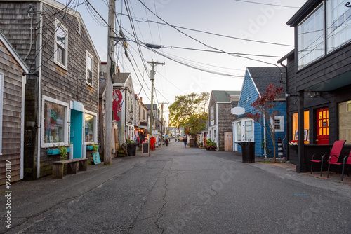 Street lined with traditional American wooden buildings and shops in a fishing village at dusk in autumn photo