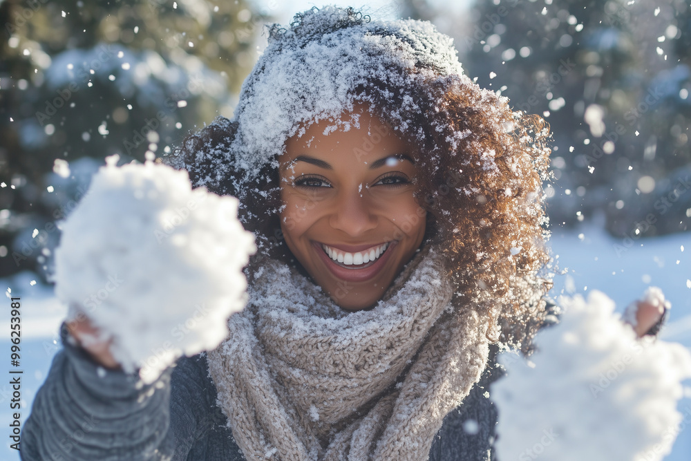 A woman with curly hair is smiling and holding snowballs in her hands A woman with curly hair is smiling and holding snowballs in her hands
