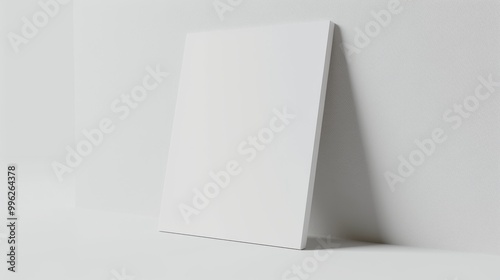 A minimalist image featuring a blank white canvas standing upright against a subtle white background, evoking a sense of simplicity and potential. photo