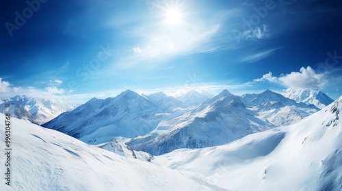 A panoramic view of a snowy mountain range under a bright, crisp blue sky, with peaks glistening in the sunlight