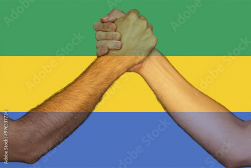 Two hands gathering front of Gabon flag, human rights, help or support for Gabon, togetherness 