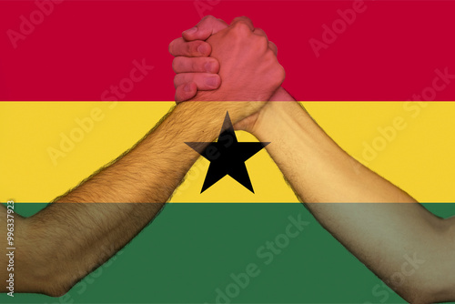 Two hands gathering front of Ghana flag, togetherness and solidarity concept, union of society