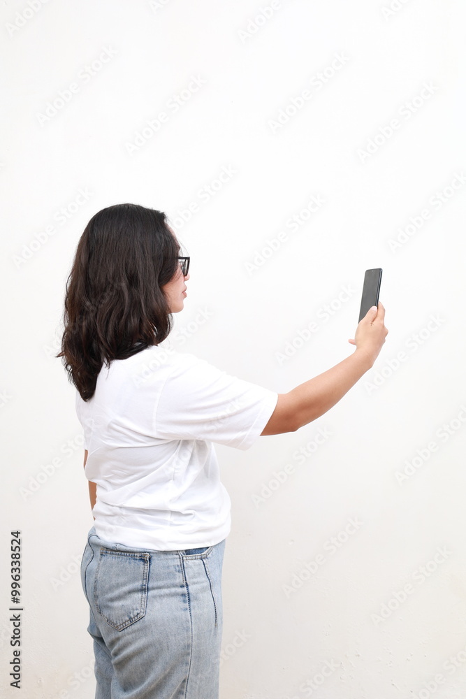 Rear view of Asian corporate woman taking photo with mobile phone. Isolated on white background. Rear view of Asian corporate woman taking photo with mobile phone. Isolated on white background.