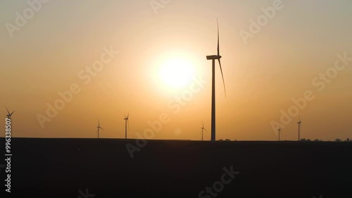 Farma wiatrowa na tle zachodzącego słońca, wiatrak, energia odnawialna
