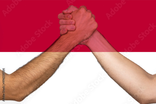 Two hands gathering front of Indonesia flag, human rights, union of society, togetherness 
