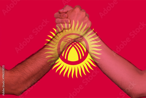Two hands gathering front of Kyrgyzstan flag, togetherness and solidarity concept, human rights