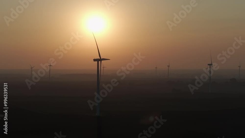Farma wiatrowa na tle zachodzącego słońca, wiatrak, energia odnawialna