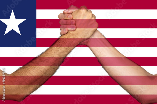 Two hands gathering front of Liberia flag, union of society, togetherness and solidarity concept