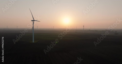 Farma wiatrowa na tle zachodzącego słońca, wiatrak, energia odnawialna