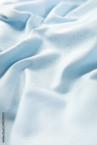 Waving grlight blue fabric background, cotton silky satin. Texture. Close-up, macrophoto