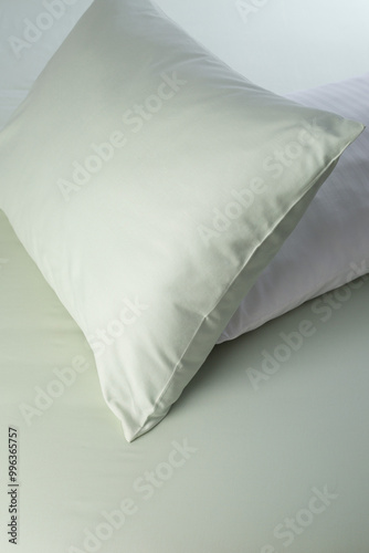 A set of light green bed linen, pillow in pillowcase on a sheet. Minimalist bedroom. Cozy home concept. Scandinavian style