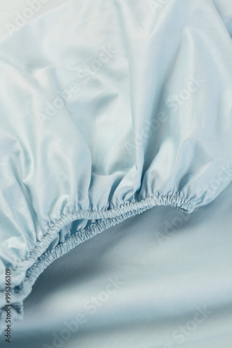 Cotton fitted sheet with elastic. Close-up, macro photo. Minimalist bedroom. Cozy home concept. Scandinavian style
