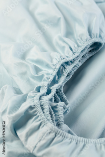 Cotton fitted sheet with elastic. Close-up, macro photo. Minimalist bedroom. Cozy home concept. Scandinavian style