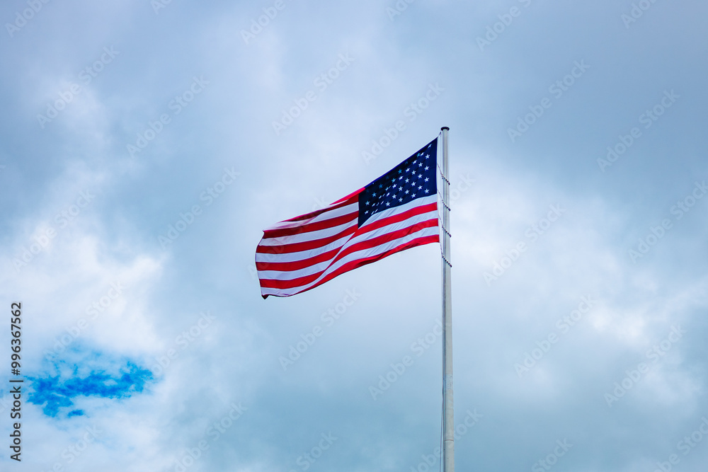 Naklejka premium Patriotic waving american flag in overcast cloudy day