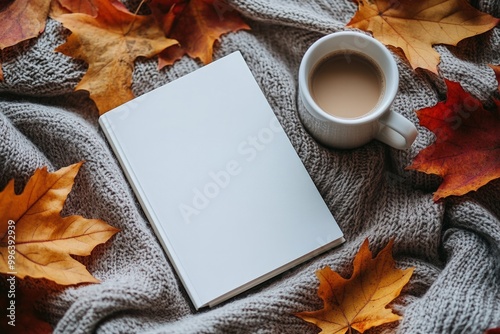 Cozy autumn scene with blank book, coffee and leaves.