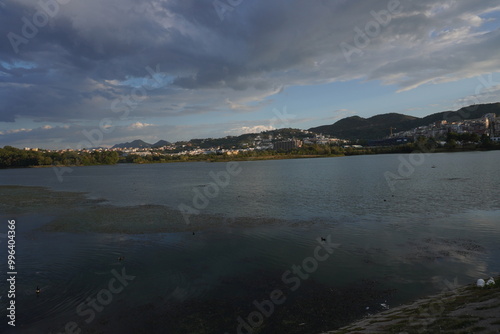 Grande parco di tirana al tramonto, vista su lago, alberi e montagne
