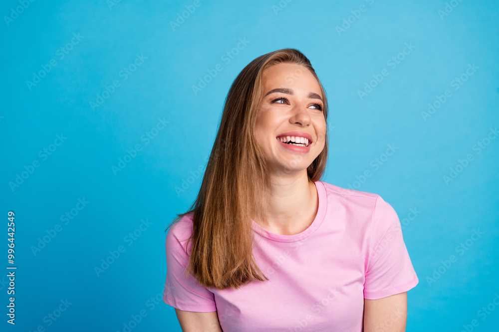 Photo portrait of pretty young girl interested look empty space wear trendy pink outfit isolated on blue color background Photo portrait of pretty young girl interested look empty space wear trendy pink outfit isolated on blue color background