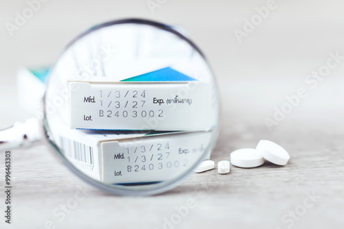 Foto Close-up of the production code and expiration date printed on the side of a medicine box, with pills placed on a table