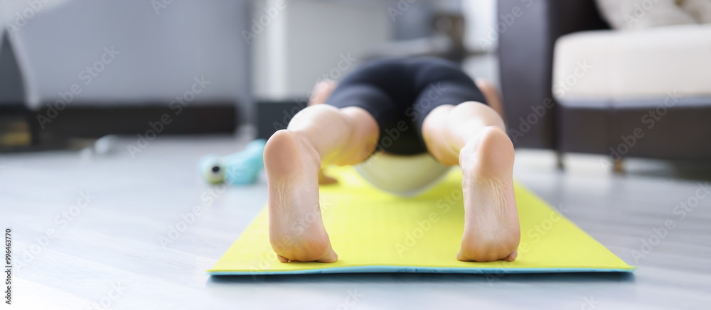 Low angle of male barefoot feet on mat performing exercise in morning for health. Good habit doing sport or yoga after waking up. Lifestyle, hobby concept Low angle of male barefoot feet on mat performing exercise in morning for health. Good habit doing sport or yoga after waking up. Lifestyle, hobby concept