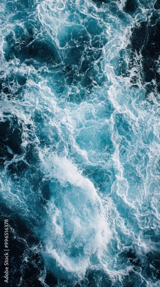 Fototapeta premium Stunning aerial view of powerful ocean waves in a turbulent sea, featuring diverse shades of blue and white foam. ideal for nature-inspired design, print, or poster.