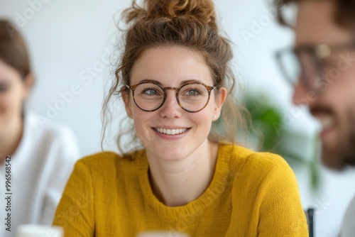 Happy woman with glasses smiling in a casual setting.