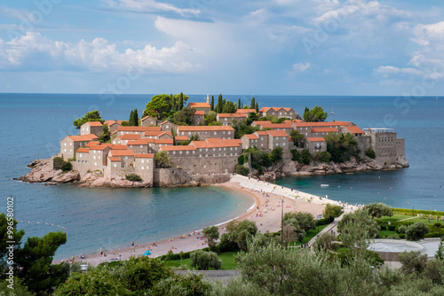 A picturesque view of Sveti Stefan island reveals its charming architecture and golden beaches, embraced by the Adriatic Sea. Visitors enjoy the calm and beauty of this unique destination.Montenegro 