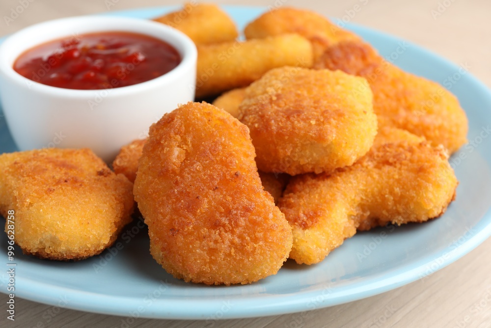 Tasty chicken nuggets with chili sauce on table, closeup Tasty chicken nuggets with chili sauce on table, closeup