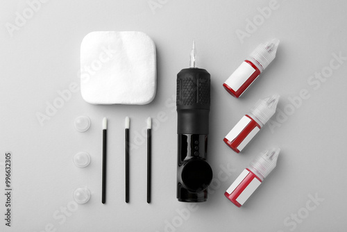 Permanent makeup equipment kit on light grey background, flat lay photo