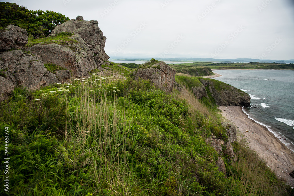 A rugged rocky cliff that majestically overlooks a calm body of water