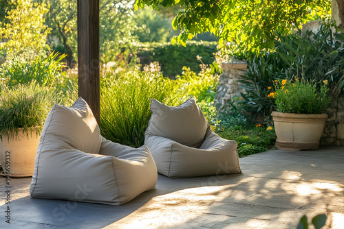 Outdoor patio with beige bean bags surrounded by lush green plants and natural light photo