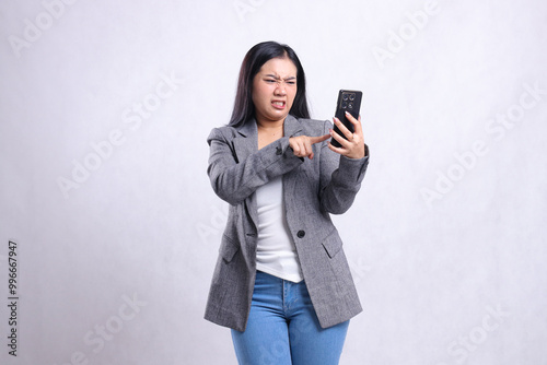 beautiful adult office woman hate to mobile phone while touching, holding cellphone wearing grey suit isolated on white background. for technology, lifestyle, shopping, transaction content