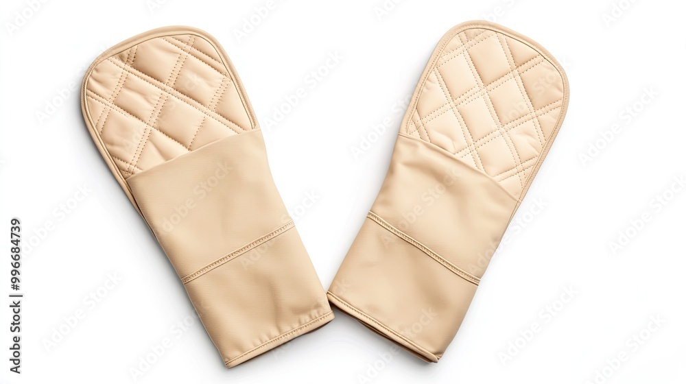 Set of beige quilted oven mitts designed for protection while handling hot cookware in the kitchen. Set of beige quilted oven mitts designed for protection while handling hot cookware in the kitchen.