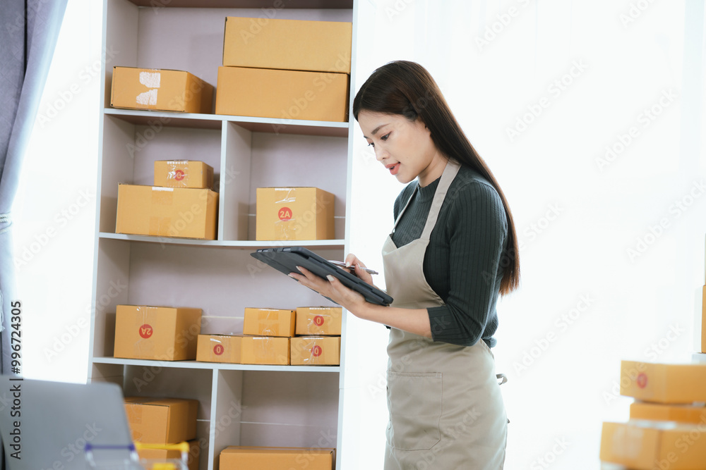 Happy Asian businesswoman runs online business from home using laptop and smartphone. She handles orders, deliveries, and drives her small retail startup to success. Happy Asian businesswoman runs online business from home using laptop and smartphone. She handles orders, deliveries, and drives her small retail startup to success.