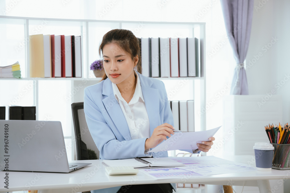 Confident and charming Asian businesswoman using laptop and smartphone. She is full of professionalism and achievement in data analysis, effective communication and organizational management in modern Confident and charming Asian businesswoman using laptop and smartphone. She is full of professionalism and achievement in data analysis, effective communication and organizational management in modern