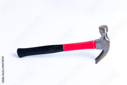 Close up medium sized hammer that has two functions as a nail pick and nail hammer, with a handle covered in black and red rubber isolated on a white background. Little bit rusty