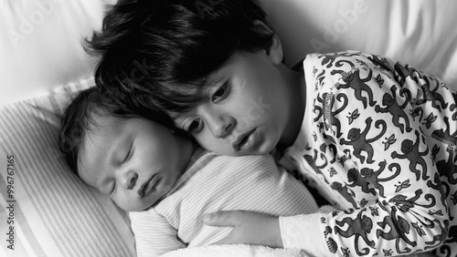 Εκτύπωση καμβά Black and white of older brother resting his head on his newborn sibling, both l