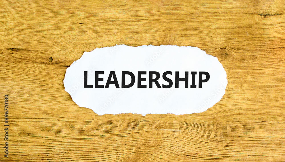 Leadership symbol. Concept word Leadership on beautiful white paper. Beautiful wooden wall background. Business leadership concept. Copy space. Leadership symbol. Concept word Leadership on beautiful white paper. Beautiful wooden wall background. Business leadership concept. Copy space.