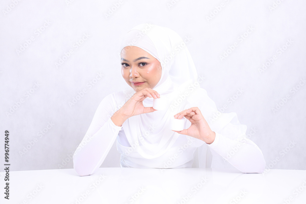Beauty Beautiful young veil woman asia smiles gracefully to the camera both hands holding cosmetic cream close together for daily skin care routine needs on white background. Facial treatment Beauty Beautiful young veil woman asia smiles gracefully to the camera both hands holding cosmetic cream close together for daily skin care routine needs on white background. Facial treatment