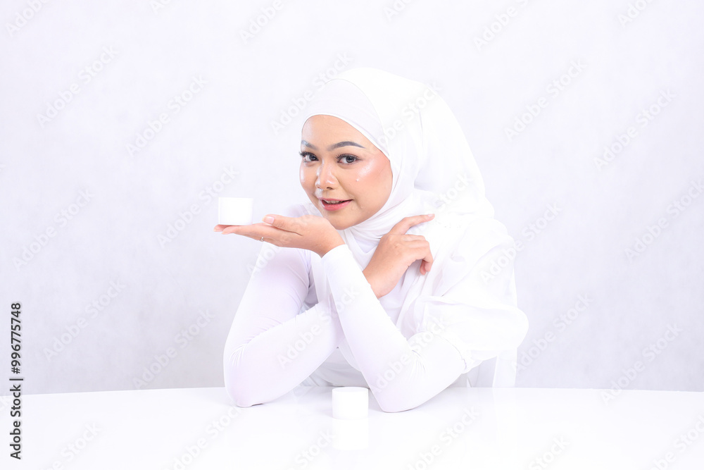 Beautiful young woman expression smile cheerful look at camera hand presenting cosmetic cream on right chin for daily skin care routine needs on white background. Facial treatment, Perfect skin