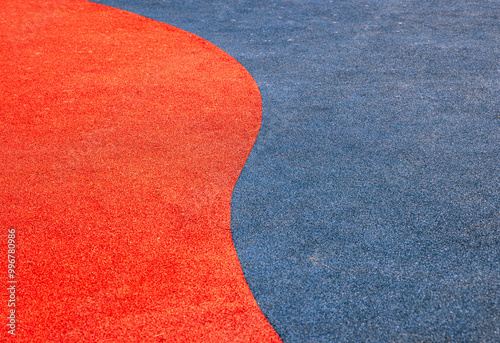 Bright red and blue textures intertwine on a playground surface, inviting joyful play and exploration under the sun. photo