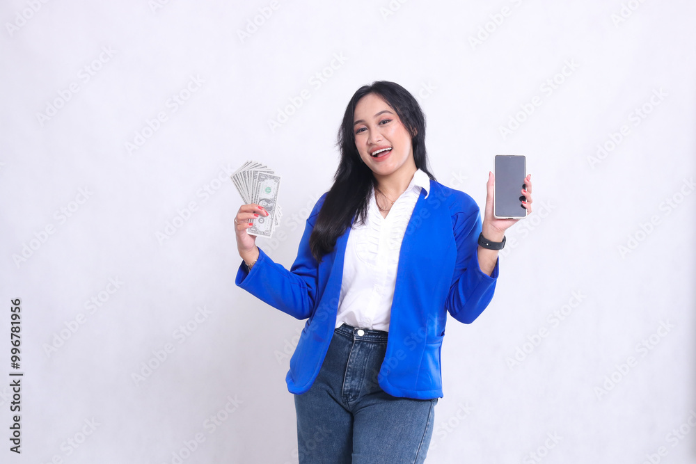 beautiful adult office woman wearing blue formal suit standing happily to camera carrying dollar money and showing smartphone screen isolated white background. for transaction, finance, business beautiful adult office woman wearing blue formal suit standing happily to camera carrying dollar money and showing smartphone screen isolated white background. for transaction, finance, business