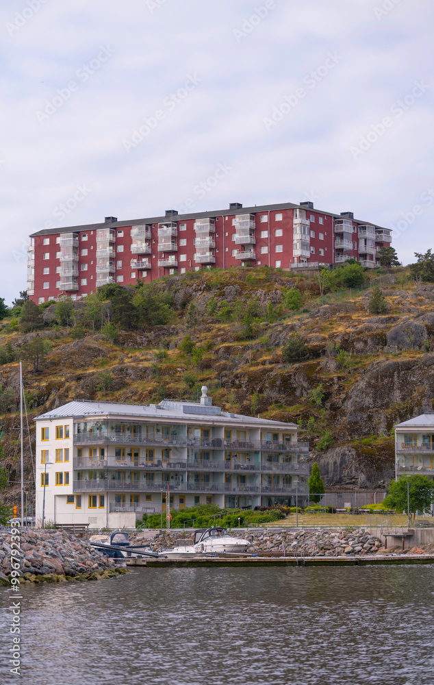 Fototapeta premium Waterfront apartment houses at the pier Finnboda and hill apartment houses on the hill Finnberget, a summer day in Stockholm