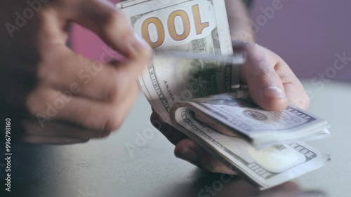 The man picks up a stack of banknotes